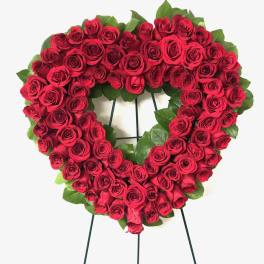 Heart-shaped wreath of red roses on a stand