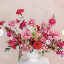 Pink and red mixed flower arrangement in a white vase