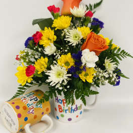 Birthday bouquet in a mug with yellow, white, red, and orange flowers
