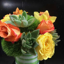 Bouquet of orange and yellow roses with succulents in a striped vase