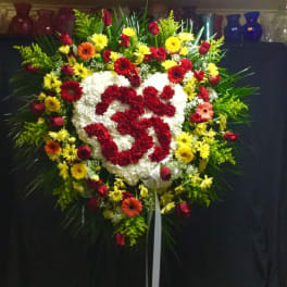 Heart-shaped floral wreath with red and white flowers and a ribbon