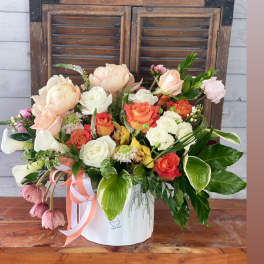 Mixed bouquet in a white hatbox with peach, white, and coral blooms