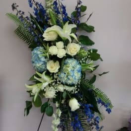 Tall blue and white floral standing spray on an easel