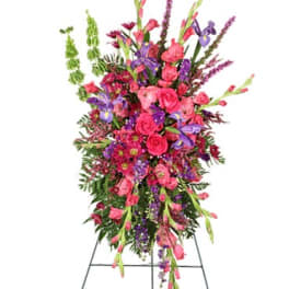 Tall standing spray of pink and purple flowers on an easel
