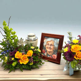 Memorial floral arrangement with framed portrait and urn