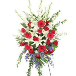 Standing floral spray with red and white flowers on a metal easel