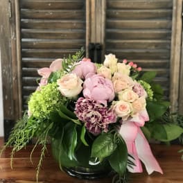 Pink and cream rose bouquet with green hydrangea in a glass vase