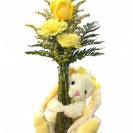 Yellow flowers in a glass vase with a plush bunny