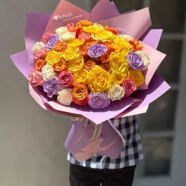 Large bouquet of multicolored roses wrapped in purple paper