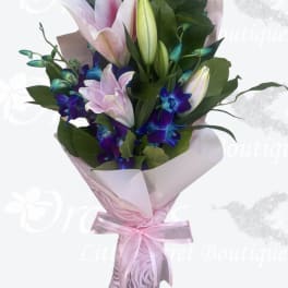 Pink and white lily bouquet with purple orchids wrapped in pink paper