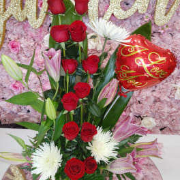 Tall bouquet of red roses, white spider mums, pink lilies, and a heart balloon