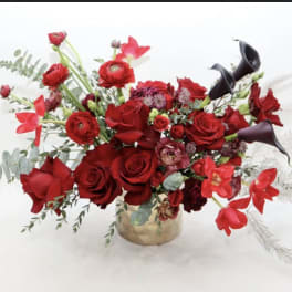 Red roses and calla lilies arranged in a low vase