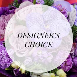 Purple and white floral arrangement with a "Designer’s Choice" label