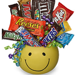 Smiley-face container filled with assorted candy bars and curled ribbons