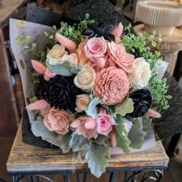 Bouquet of pink and cream flowers with black accents and greenery