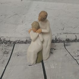 Two carved figurines of a woman and child in white robes