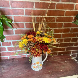Autumn bouquet of chrysanthemums in a floral pitcher vase