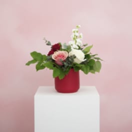 Bouquet of pink, white, and red flowers in a red vase
