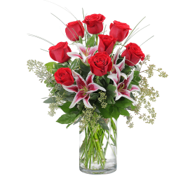 Red roses and pink lilies in a clear glass vase