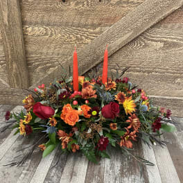 Autumn floral centerpiece with red candles and mixed blooms