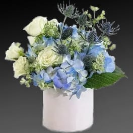 Blue and white floral arrangement in a white vase