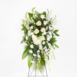 Standing spray of white roses and mixed white flowers on an easel