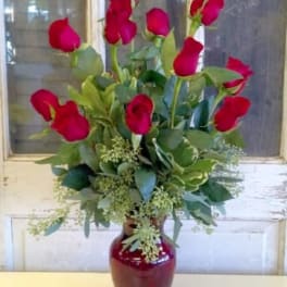 Red roses arranged in a red vase