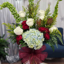 Bouquet of white and red roses with blue hydrangea in a glass vase