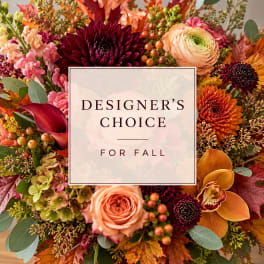 Fall floral arrangement with roses, dahlias, and orchids around a center card