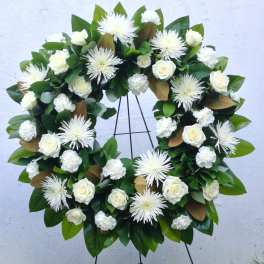 White rose and chrysanthemum wreath on a black stand