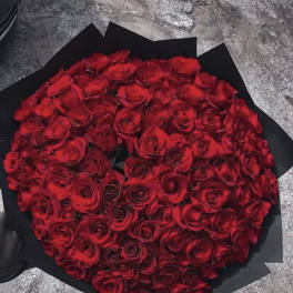 Large bouquet of red roses wrapped in black paper