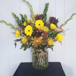 Yellow and burgundy mixed bouquet in a glass vase