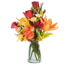 Mixed bouquet of red roses and orange lilies in a glass vase