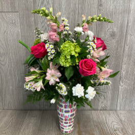 Mixed bouquet with pink roses, white daisies, and green hydrangea in a printed vase