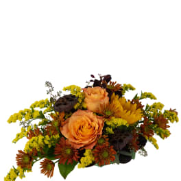 Orange roses and yellow chrysanthemums in a low arrangement