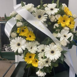 Heart-shaped floral wreath with white and yellow daisies and roses