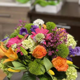 Colorful mixed bouquet with roses, lilies, and daisies in a vase