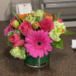 Pink and orange mixed bouquet in a glass vase