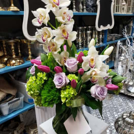White orchids and lavender roses in a vase with pink tulips