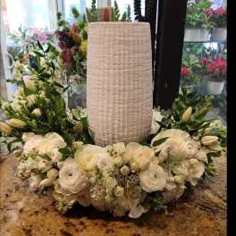 White floral wreath around a tall textured vase