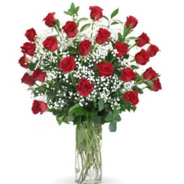 Red roses in a clear glass vase with white filler flowers