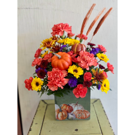 Fall floral arrangement in a pumpkin-decorated square container