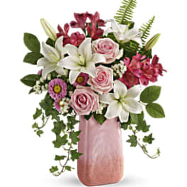 Pink and white floral arrangement in a tall pink vase