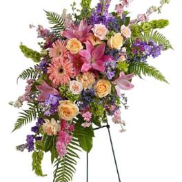 Tall floral standing spray with pink lilies, roses, and purple flowers