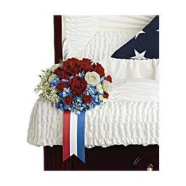 Red, white, and blue floral spray on a draped casket