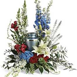 Sympathy floral arrangement with a blue urn and mixed lilies, roses, and delphinium