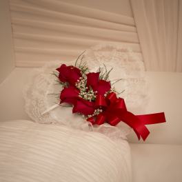 Red rose corsage with white lace and ribbon