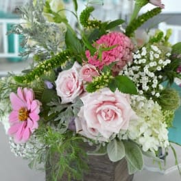 Mixed pink and white flowers in a square wooden container