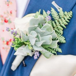 Boutonniere with pale succulent and lavender accents on a blue suit