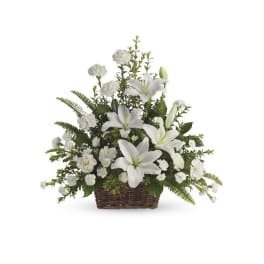 White lilies and carnations arranged in a wicker basket